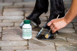 The Keralit Hoof Strengthener is applied to a horse's hoof with a brush