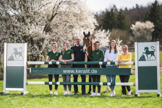 Fünf Frauen und ein Mann stehen hinter einem Hindernis für Pferde mit der Aufschrift www.keralit.de